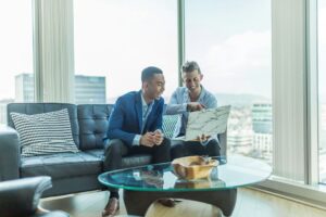 Tenant reviewing a commercial lease beside floor plans, keys, and a calculator on a desk