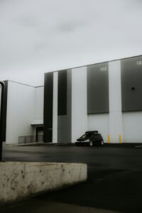 A business owner reviews lease documents beside a commercial building with parking and warehouse space.