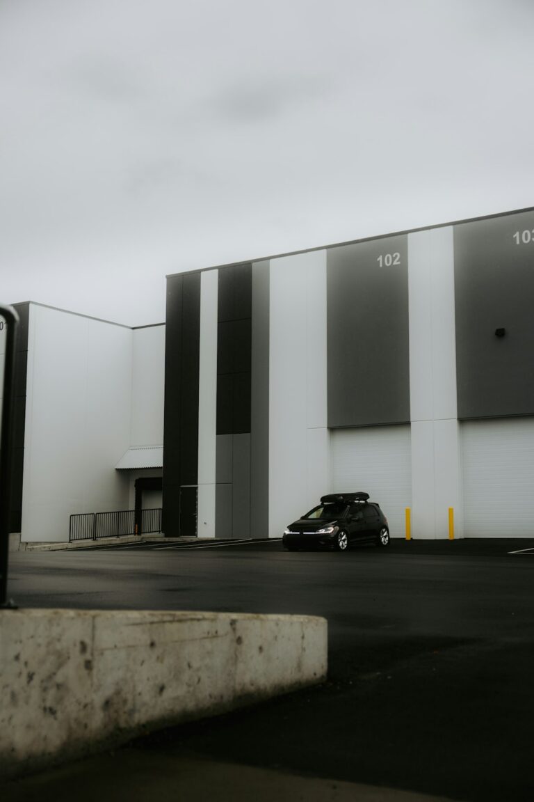 A business owner reviews lease documents beside a commercial building with parking and warehouse space.
