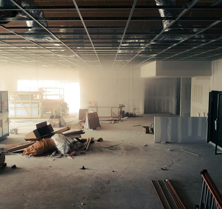 Business owners review floor plans beside a commercial storefront with parking and loading access.